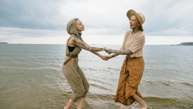 Women dancing on the ocean shoreline
