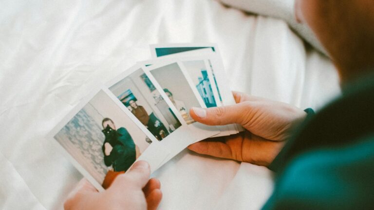 Man, looking over Polaroid photos.