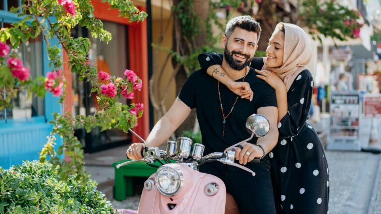 Couple rides a moped.