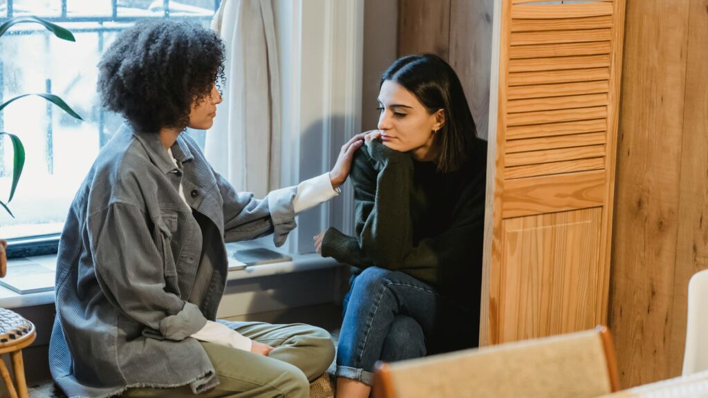 Woman comforting another woman.