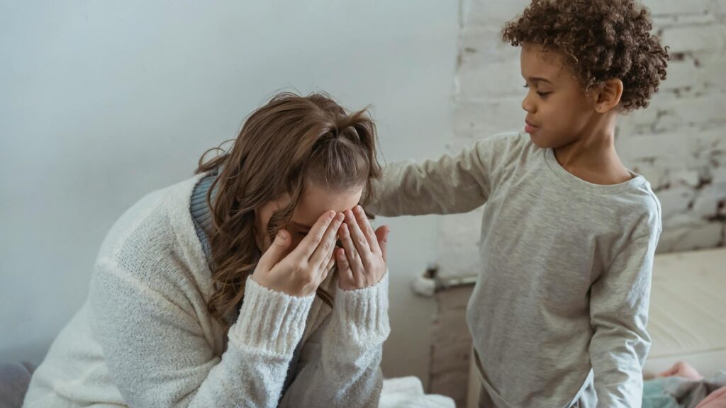 Child comforts upset mother.