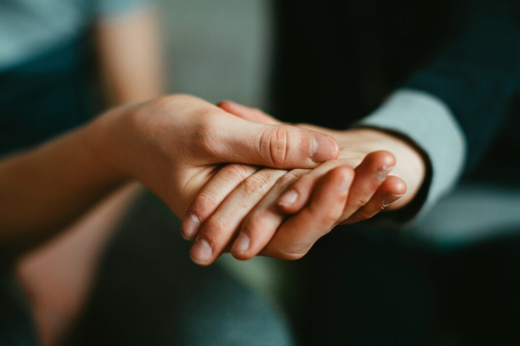 Two people holding hands with their hands in the center of the frame.